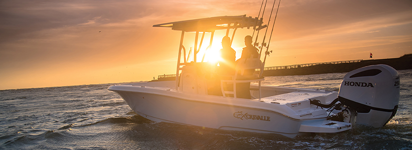 A boat using a Honda outboard on the water at sunset